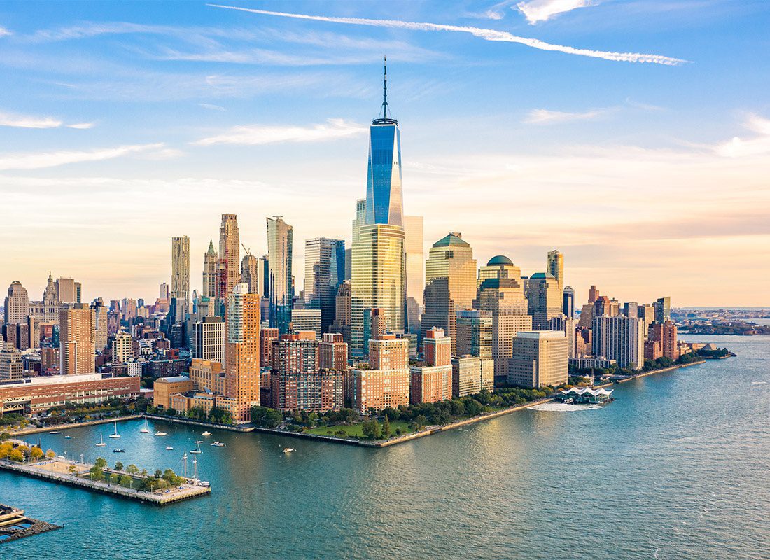 About Our Agency - Aerial View of the Lower Manhattan Skyline at Sunset Viewed From Above Hudson River