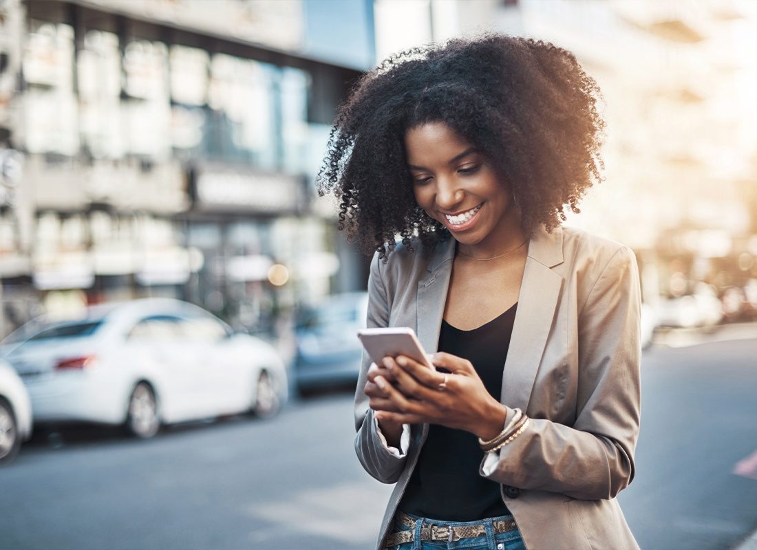 Read Our Reviews - Shot of a Young Businesswoman Using a Cellphone in the City