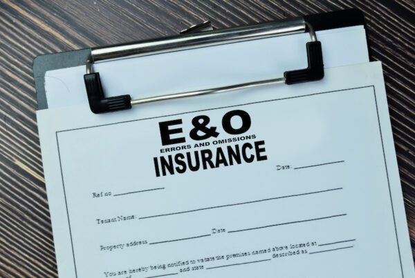The Importance of E&O Insurance for General Contractors - Clipboard on a desk with an E&O Insurance Document